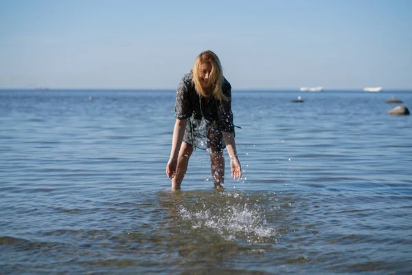 시폰 드레스에 매력적인 플러스 사이즈 여성은 푸른 바다에서 반짝이는 물을 즐긴다 — 스톡 사진