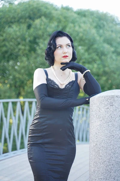 Retro woman in classic pin up dress on the bridge in the city park — Stock Photo, Image