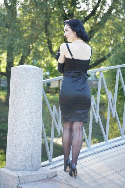 Femme rétro en robe pin up classique sur le pont dans le parc de la ville — Photo