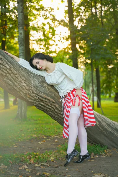 Close-up van een gelukkige jonge pin-up meisje poseren met boom in het Park — Stockfoto