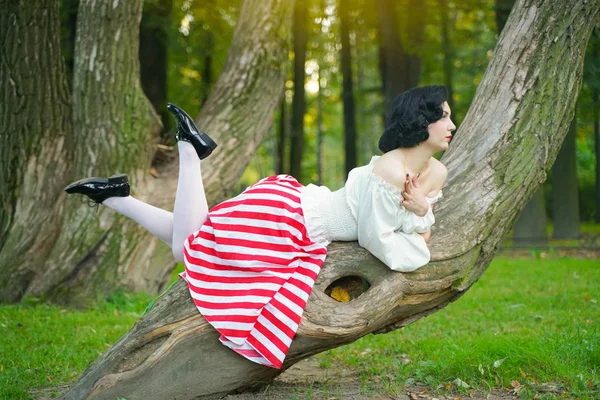 公園で木とポーズをとる幸せな若いピンアップ女の子のクローズアップ — ストック写真