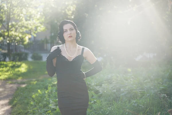 Retrato de hermosa chica pinup en vestido negro al aire libre en la naturaleza —  Fotos de Stock