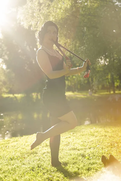 Belle jeune femme avec pin-up maquillage et coiffure posant dans le parc de la ville d'été — Photo