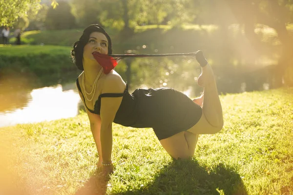 Kaunis nuori nainen pin-up meikki ja kampauksen poseeraa kesällä kaupungin puistossa — kuvapankkivalokuva
