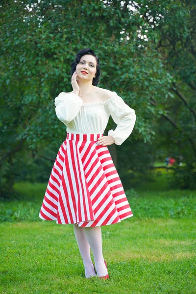 Ritratto vintage di una donna in abito retrò bianco e rosso nel parco cittadino — Foto Stock