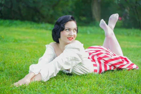 Ritratto vintage di una donna in abito retrò bianco e rosso nel parco cittadino — Foto Stock