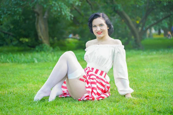 Vintage-Porträt einer Frau im Retro-Weiß-Rot-Kleid im Stadtpark Stockbild