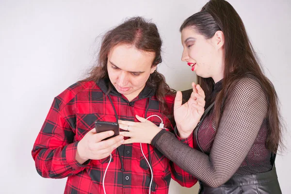 魅力的なセクシーな女性は、彼がスマートフォンを使用している間、男性を誘惑しています — ストック写真