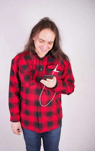 Dlouhý chlupový muž v Kostkové červené košili s telefonem na bílém pozadí ve studiu — Stock fotografie