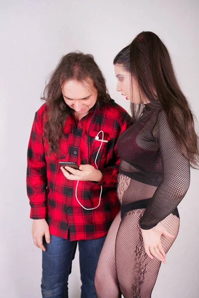 O beyaz arka plan üzerinde akıllı telefon kullanırken Çekici seksi kadın adam baştan