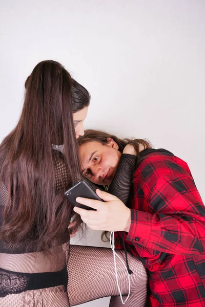 Attraktiv sexig kvinna förför nörd man medan han använder smartphone på vit bakgrund — Stockfoto