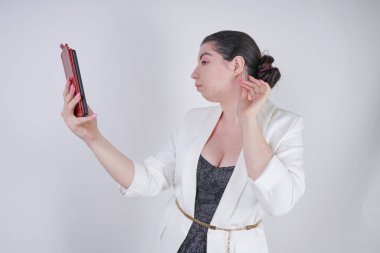 büyüleyici mix yarış artı beyaz bir iş ceketi boyutu kadın Studio beyaz arka planda elinde akıllı telefon ile selfie fotoğraf çekmek