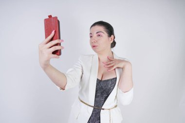 büyüleyici mix yarış artı beyaz bir iş ceketi boyutu kadın Studio beyaz arka planda elinde akıllı telefon ile selfie fotoğraf çekmek