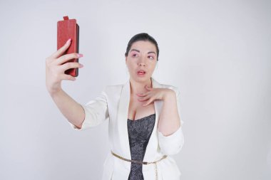 büyüleyici mix yarış artı beyaz bir iş ceketi boyutu kadın Studio beyaz arka planda elinde akıllı telefon ile selfie fotoğraf çekmek