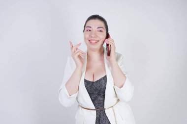 mutlu mix yarış artı beyaz bir iş ceketi arama ve Studio beyaz arka plan üzerinde elinde akıllı telefon ile konuşurken boyutu kadın