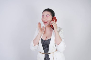 mutlu mix yarış artı beyaz bir iş ceketi arama ve Studio beyaz arka plan üzerinde elinde akıllı telefon ile konuşurken boyutu kadın