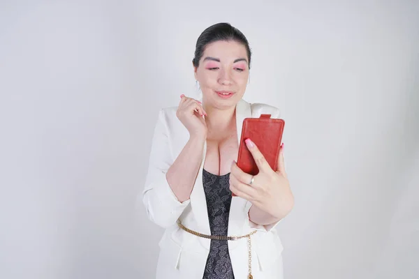 Affascinante mix race plus size donna in una giacca bianca aziendale scattare foto selfie con smart phone in mano su sfondo bianco in Studio — Foto Stock