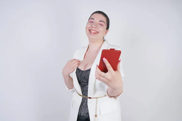Encantador mix race plus size woman in a white business jacket do vídeo call with smart phone in hand on white background in Studio — Fotografia de Stock