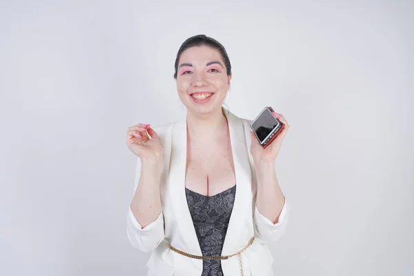 Ευτυχισμένο Mix αγώνα συν το μέγεθος γυναίκα σε ένα λευκό επιχειρηματικό μπουφάν καλώντας και μιλώντας με το smartphone στο χέρι σε λευκό φόντο στο στούντιο — Φωτογραφία Αρχείου