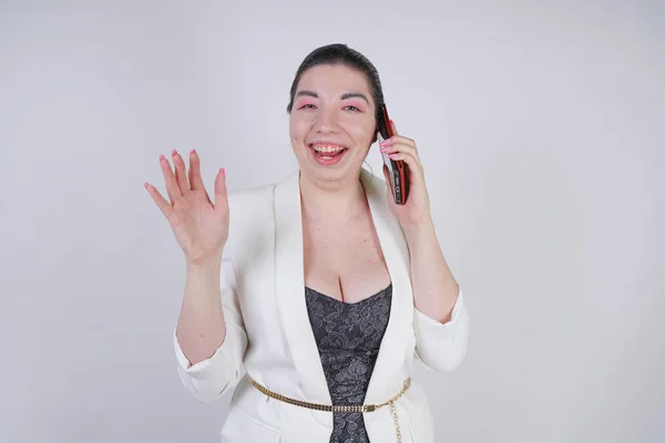 Happy mix race plus size woman in a white business jacket call and talking by smartphone in hand on white background in Studio — Fotografia de Stock