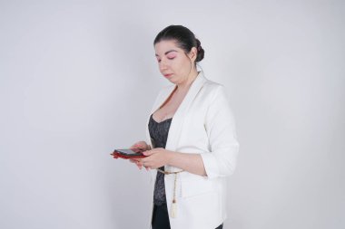 büyüleyici mix yarış artı studio beyaz arka plan üzerinde elinde akıllı telefon ile ayakta beyaz bir iş ceketi boyutu kadın