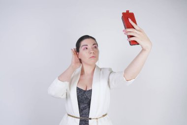 büyüleyici mix yarış artı studio beyaz arka plan üzerinde elinde akıllı telefon ile ayakta beyaz bir iş ceketi boyutu kadın