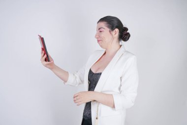 büyüleyici mix yarış artı studio beyaz arka plan üzerinde elinde akıllı telefon ile ayakta beyaz bir iş ceketi boyutu kadın