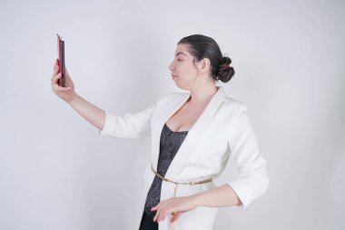 büyüleyici mix yarış artı studio beyaz arka plan üzerinde elinde akıllı telefon ile ayakta beyaz bir iş ceketi boyutu kadın