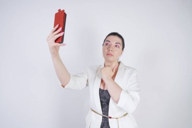 büyüleyici mix yarış artı studio beyaz arka plan üzerinde elinde akıllı telefon ile ayakta beyaz bir iş ceketi boyutu kadın