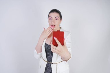 büyüleyici mix yarış artı studio beyaz arka plan üzerinde elinde akıllı telefon ile ayakta beyaz bir iş ceketi boyutu kadın