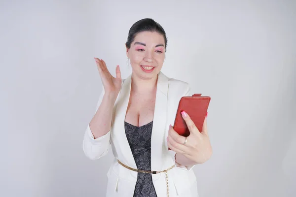 매력적인 믹스 레이스 플러스 스튜디오에서 흰색 배경에 손에 스마트 폰으로 서 흰색 비즈니스 재킷에 크기 여자 — 스톡 사진