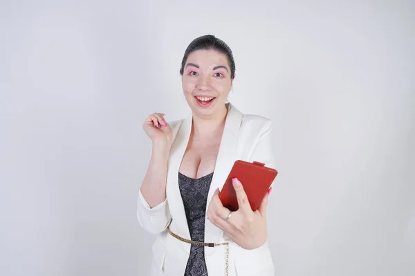 Charming mix race plus size woman in a white business jacket standing with smart phone in hand on white background in Studio — Stock Photo, Image