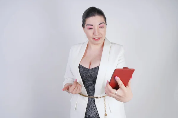 Charming mix race plus size woman in a white business jacket standing with smart phone in hand on white background in Studio — Stock Photo, Image