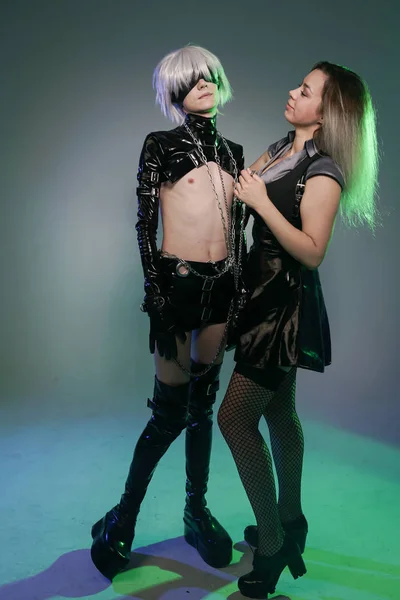 Amantes jogos de interpretação de personagens. Menina vestida com vestido de fetiche preto e joga no bdsm com seu namorado . — Fotografia de Stock