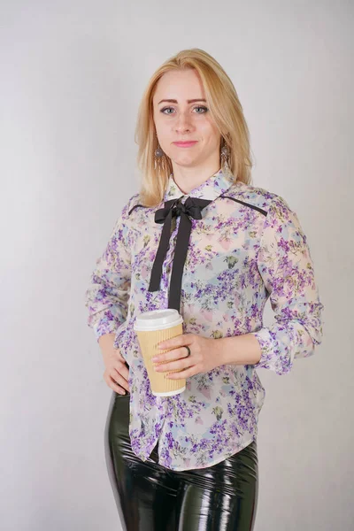 Jeune jolie femme avec tasse de café en papier sur fond de studio blanc — Photo