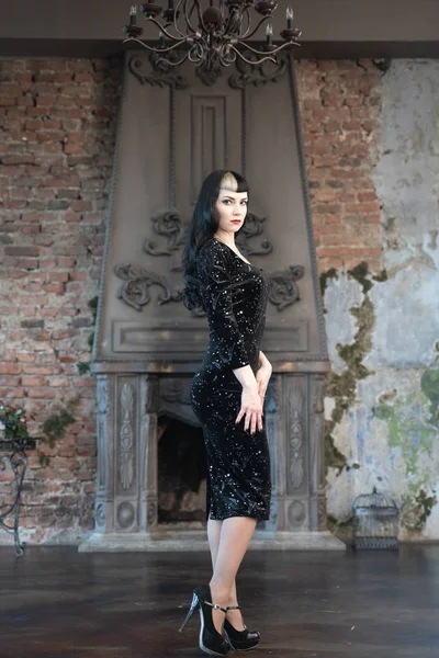 Gotická štíhlá Kavkazská dívka v černých těsných šatech představujících její pokoj — Stock fotografie