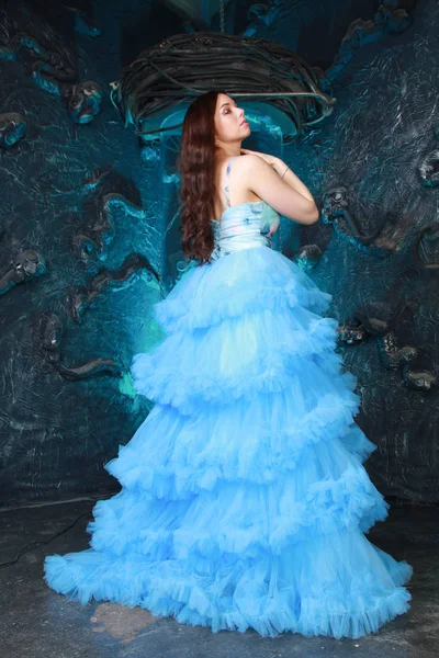 Portrait de jeune femme en robe longue bleue de soirée sur fond de studio — Photo