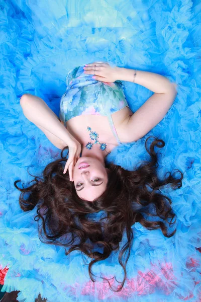 Portrait de jeune femme en robe longue bleue de soirée sur fond de studio — Photo