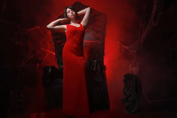 Cadılar bayramı tahtı nda uzun kırmızı elbisegüzel yalnız kız korkunç parti için hazır — Stok fotoğraf