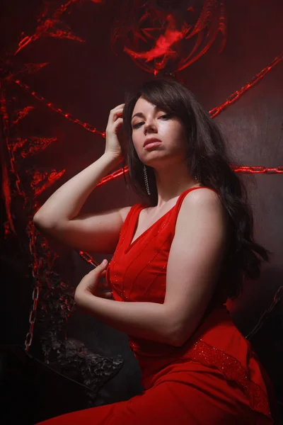 Belle fille solitaire en robe rouge longue sur le trône d'Halloween prêt pour la fête effrayante — Photo