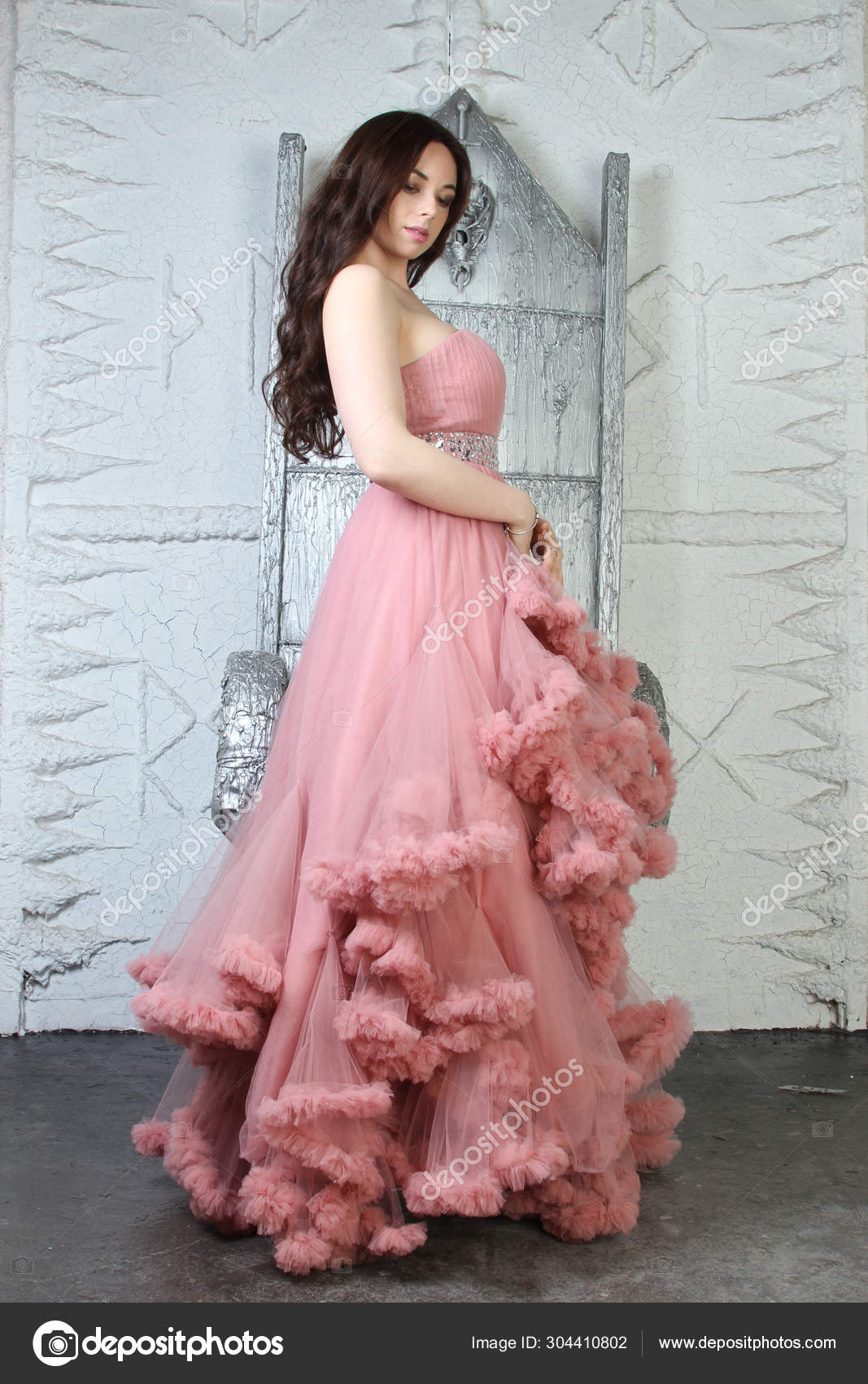 Young brunette model poses in long bridal dress with lace on fashion  background Stock Photo by ©mochak 137031648