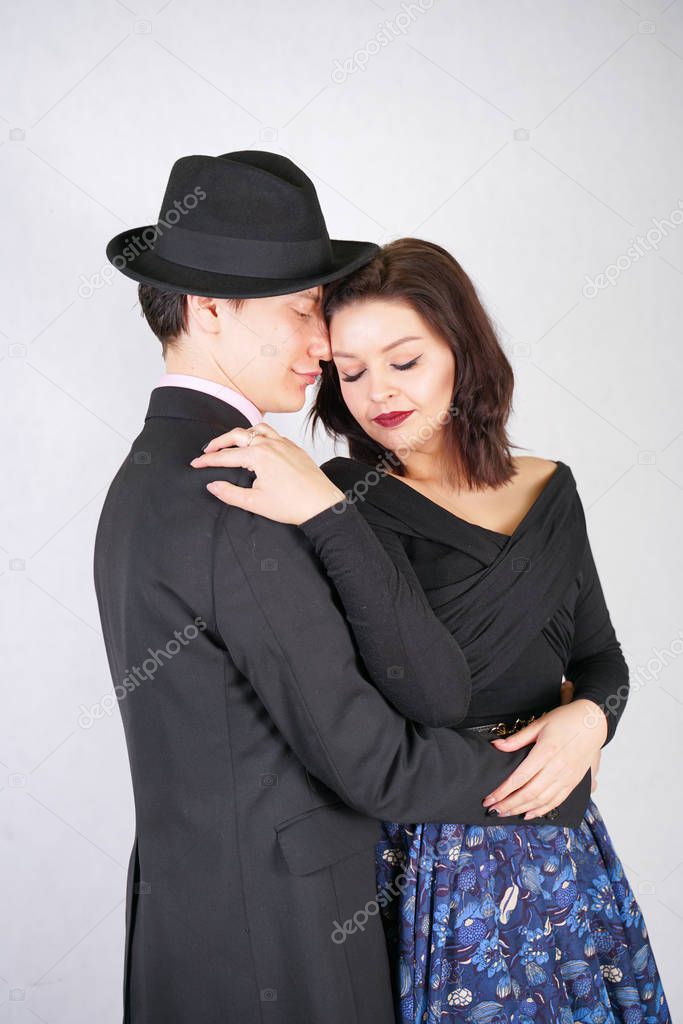 Happy couple in love hug each other on white studio background