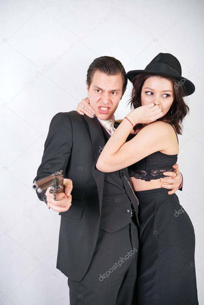 man in classic costume with gun protect his girlfriend on white studio background