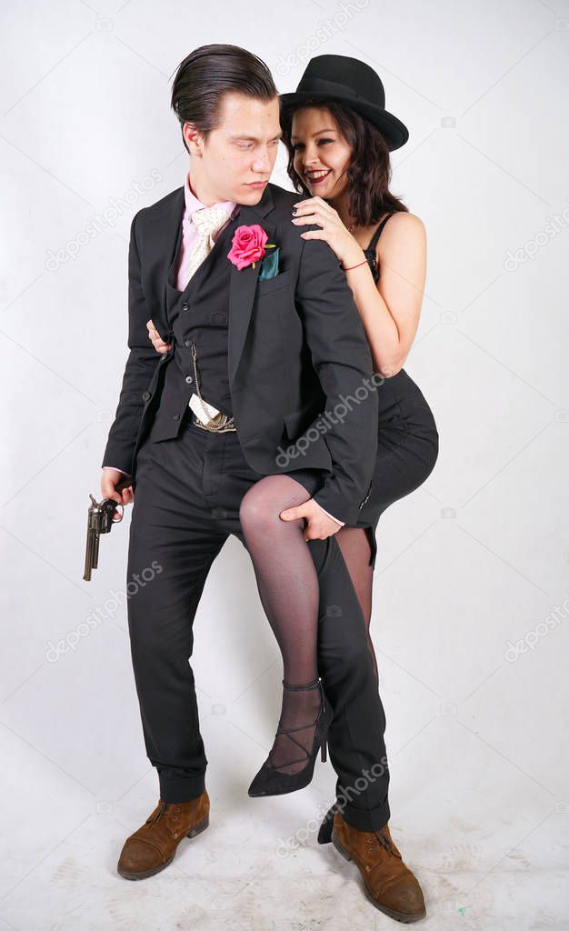man in classic costume with gun protect his girlfriend on white studio background