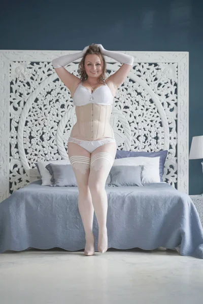 혼자 침실에서 흰색 란제리에 성적 플러스 크기의 신부 소녀. 코르셋과 스타킹 혼자 레이스 속옷에 통통한 여자 — 스톡 사진