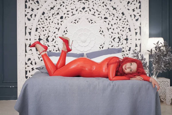 Femme sensuelle en costume de latex dans le studio. Chaud plus taille fétiche adulte fille en catsuit en caoutchouc. longueur totale du corps . — Photo