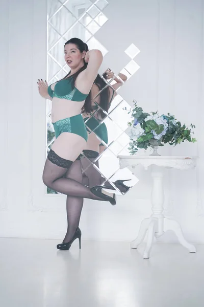Feliz plus size mix raça mulher posando na moda lingerie e meias dentro de casa em apartamento branco sozinho — Fotografia de Stock