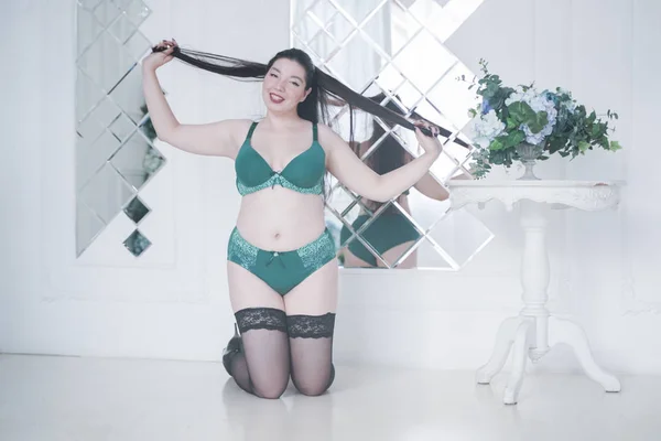 Feliz plus size mix raça mulher posando na moda lingerie e meias dentro de casa em apartamento branco sozinho — Fotografia de Stock