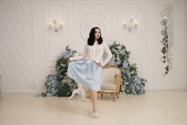 Retro sevimli pamuklu elbise güzel kadın onu beyaz dairede kapalı poz. Çorap ile vintage kıyafetli moda bayan.