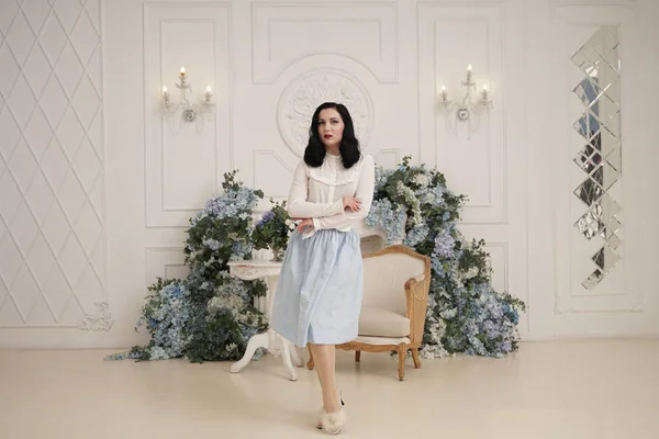 Mujer encantadora en retro lindo vestido de algodón posando en el interior de su apartamento blanco. Señora de la moda en traje vintage con medias . — Foto de Stock
